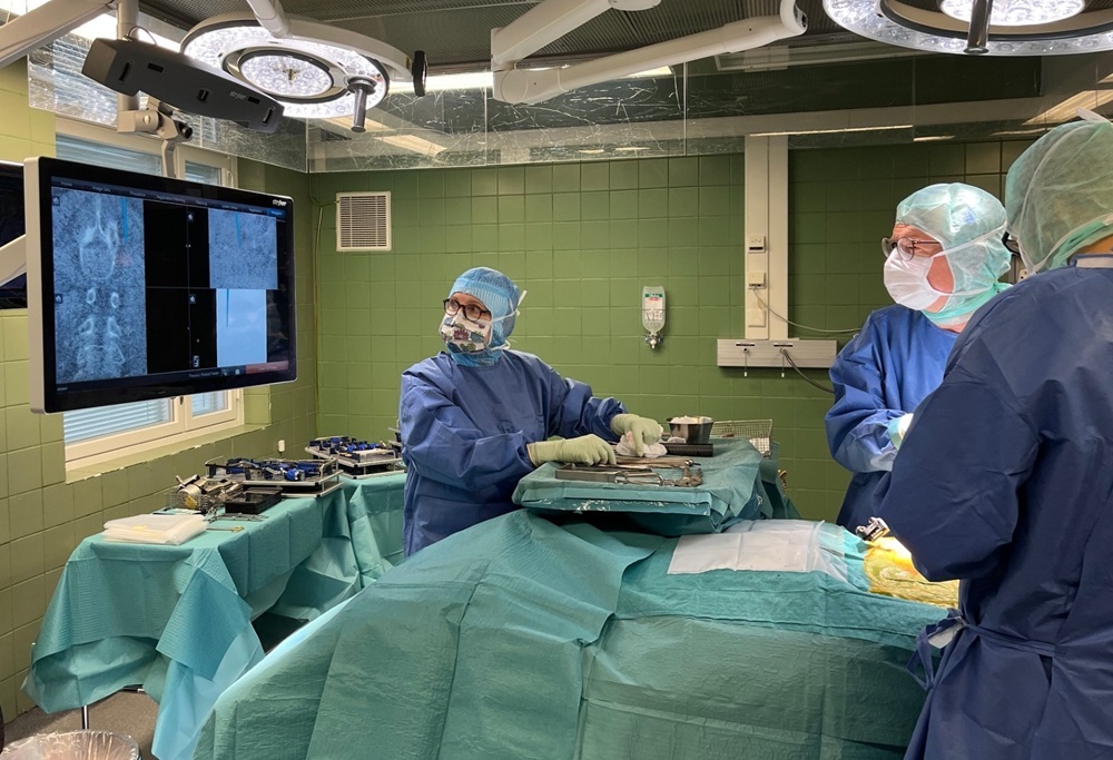 Kirurgi ja sairaalahenkilökuntaa suorittamassa selkäleikkausta navigaatiollalaitteella.